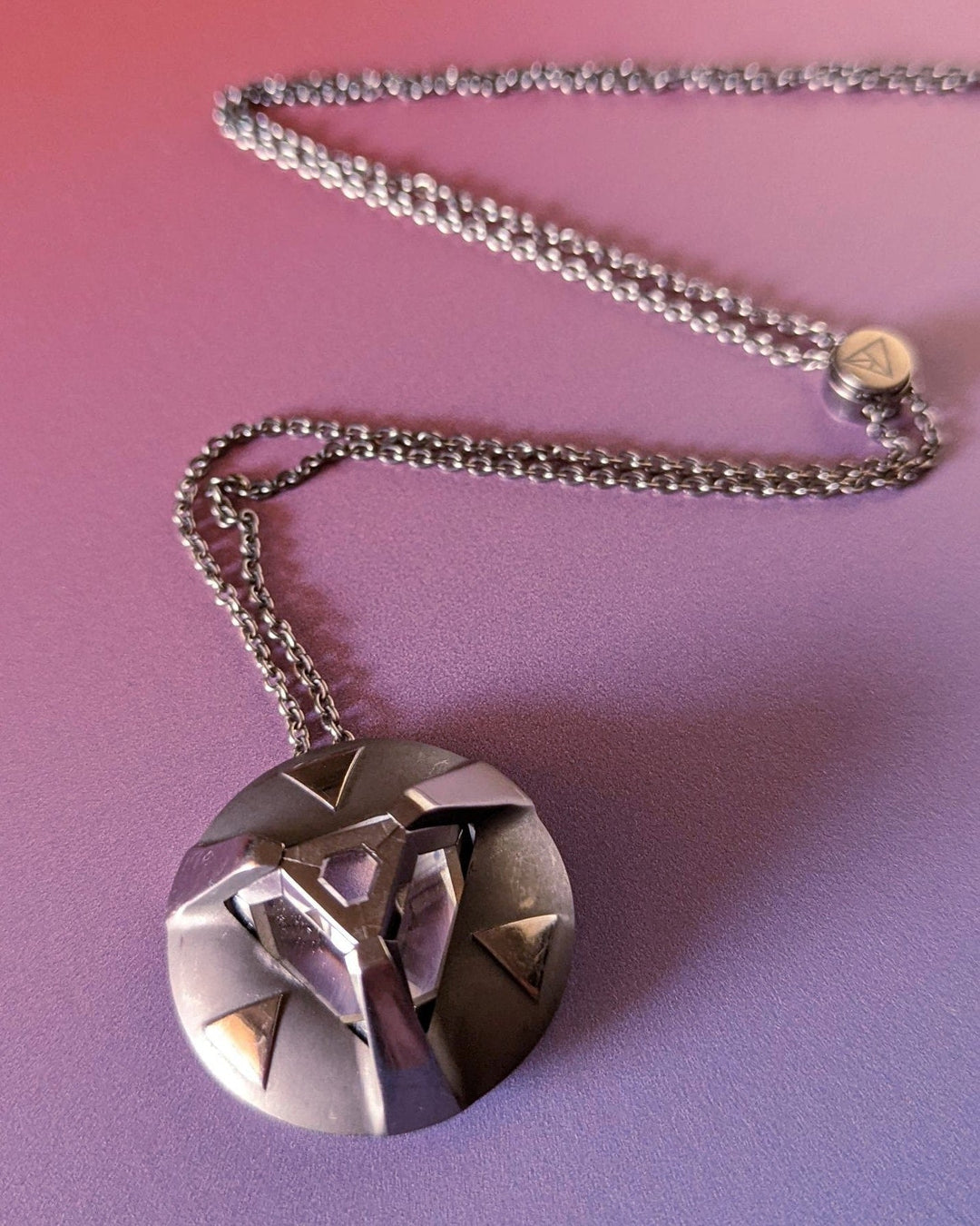 A wearable crystal pendant on a chain necklace