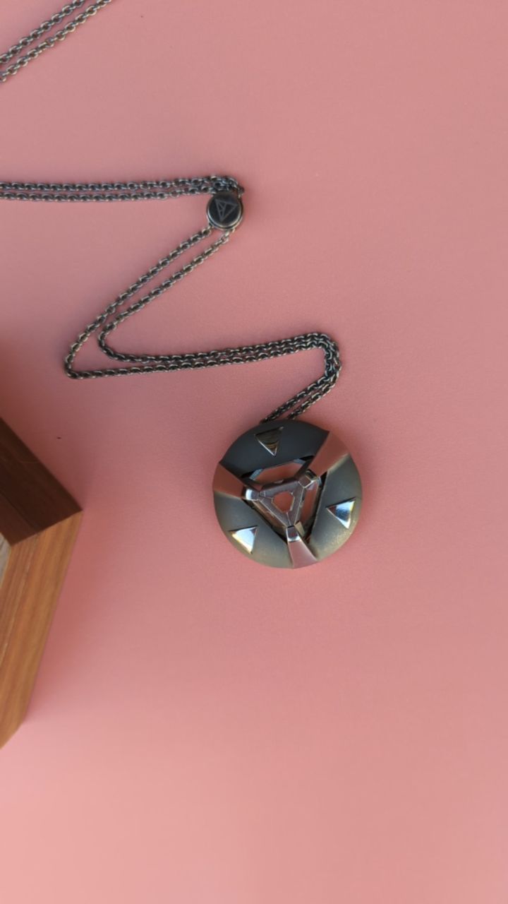 ARK crystal necklace on pink background