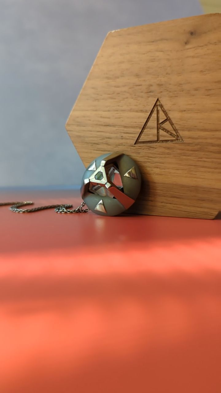 ARK crystal pendant leaning against the wooden box