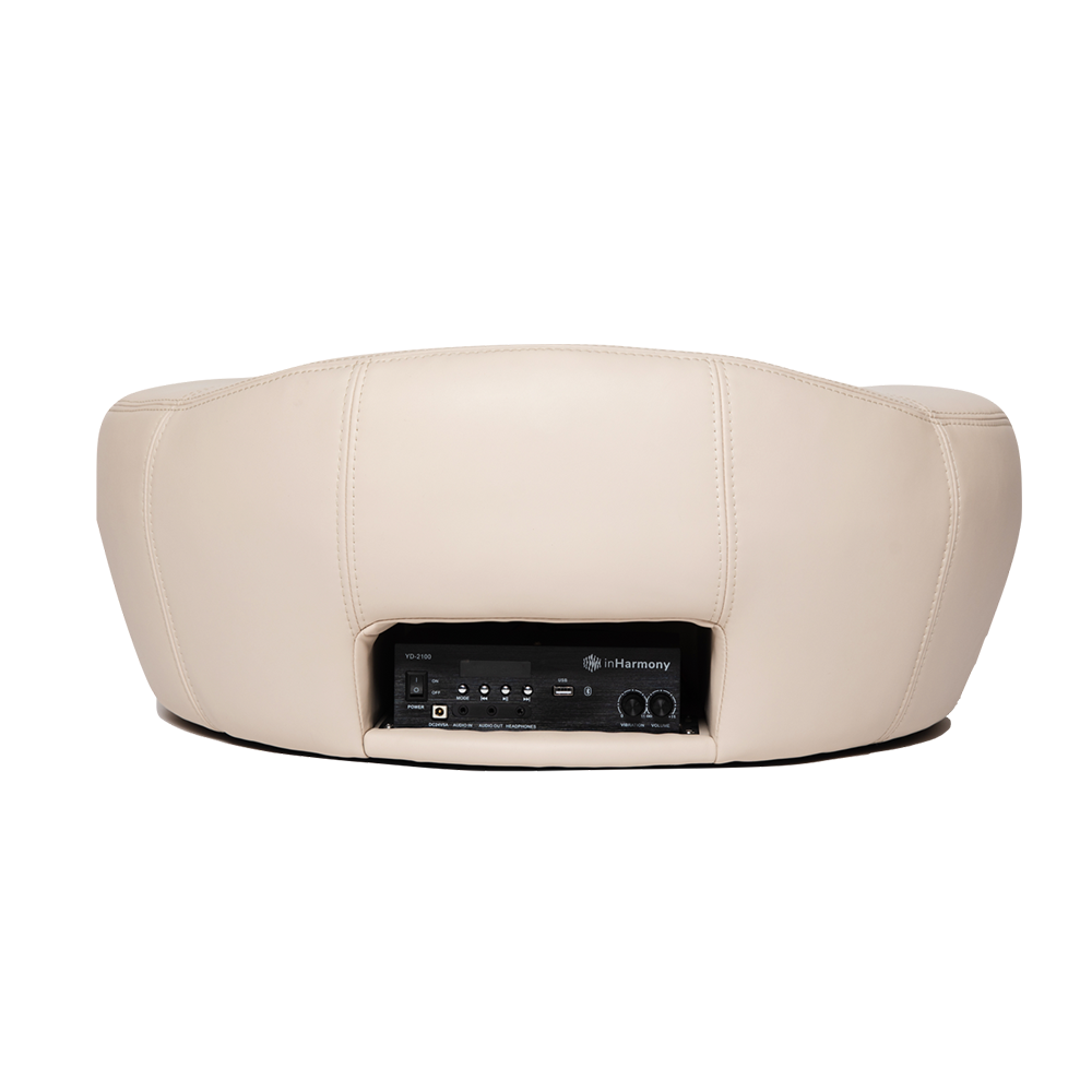 A backview of a white cushion with a hole in the lower middle, which houses a radio-like instrument where it has a power switch, jacks, usb port, and dials with a logo in it that says inHarmony