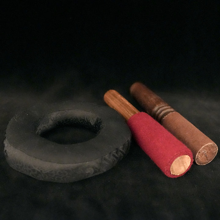 A small, round pillow with a hole in the middle, beside it are two wooden sticks